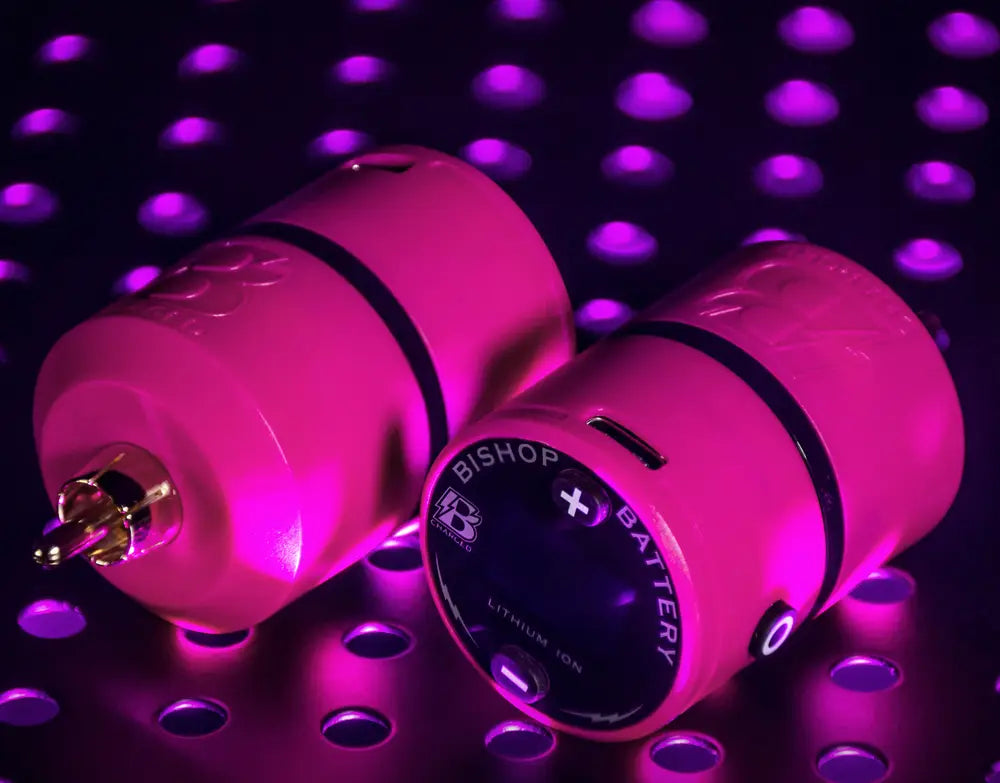 Close-up of Bishop Pink B-Charged V2 Wireless Power Supply featuring RCA connection and lightweight build for tattoo artists.